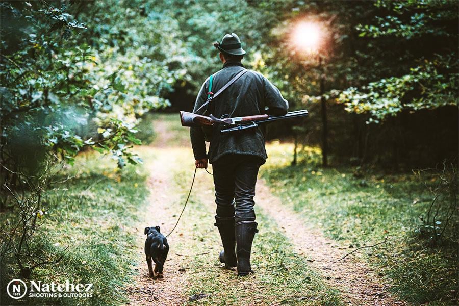 A hunter with his rifle shooting 308 ammo with his dog in the forest?