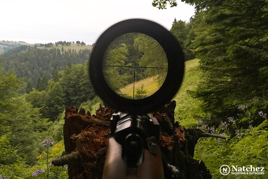 A hunter looking through a scope in the forest?