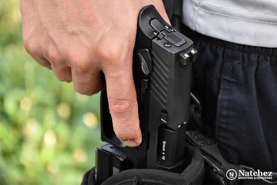 A man taking a 9mm pistol out of a holster?
