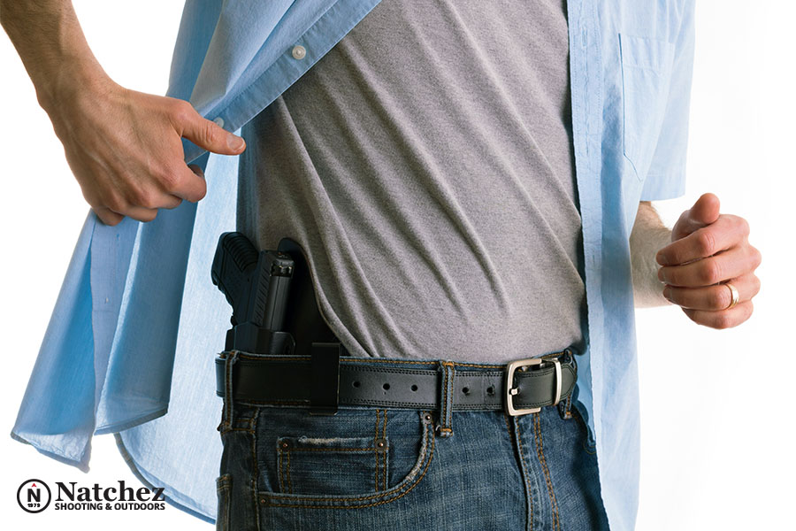A man showing his gun holster under a loose shirt?