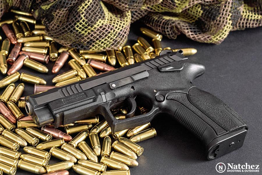 Brass and bronze bullets next to a gun?