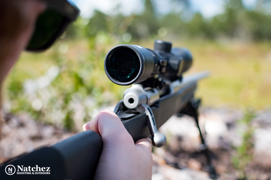 An image depicting a man aiming through a type of scope attached to a rifle?