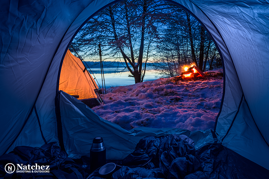 A couple drinking hot tea near the fire during winter camping?
